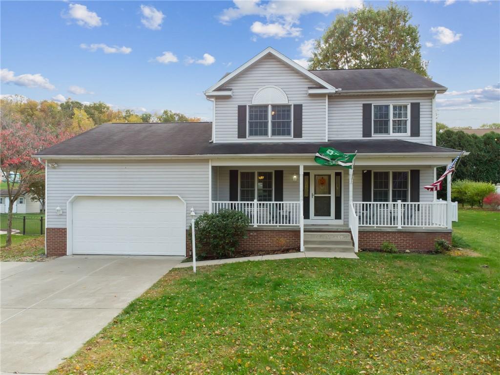 a front view of a house with a garden and yard
