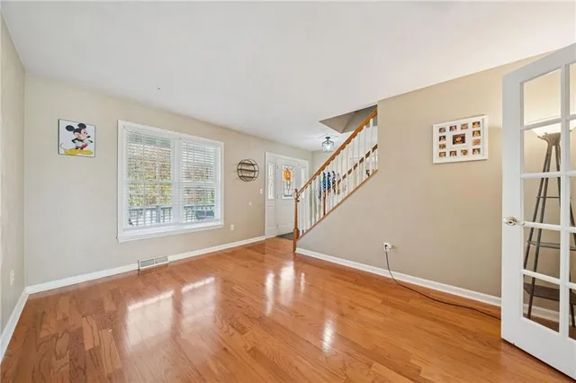 a view of empty room with wooden floor