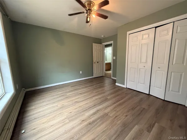 an empty room with wooden floor and window