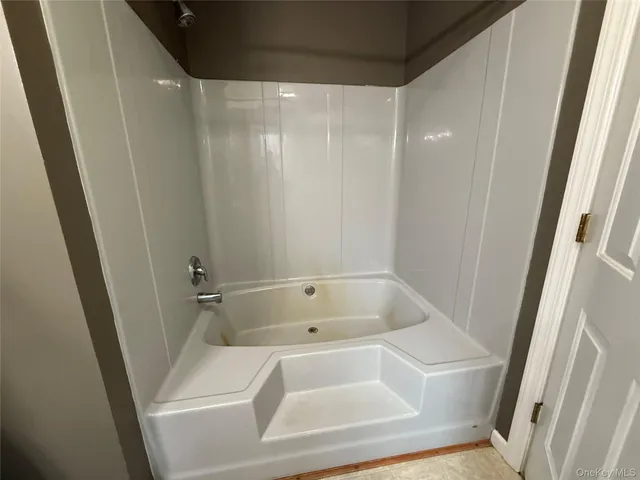 a bathroom with a sink a toilet a mirror and tub