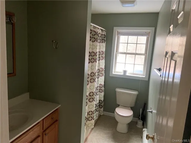 a bathroom with a toilet a sink and a window