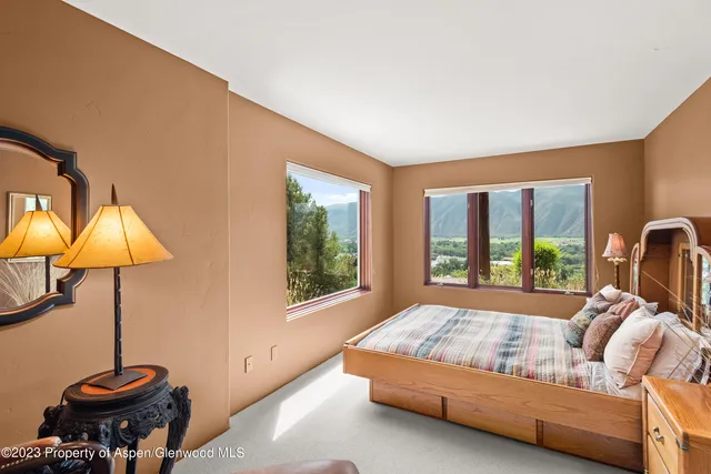 a bedroom with a bed and lamp next to a window