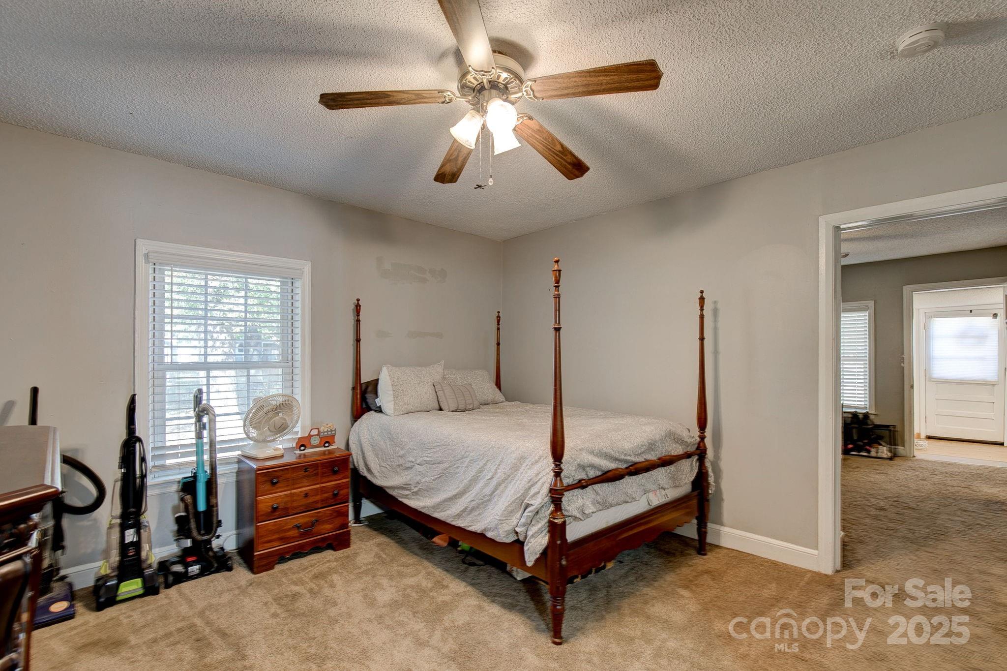 951 Evans Mill Road Pageland, SC 29728 - Photo 14 of 28 a bedroom with a bed and a chandelier