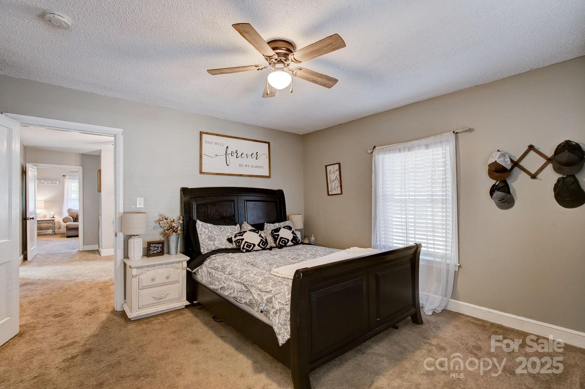 951 Evans Mill Road Pageland, SC 29728 - Photo 19 of 28 a bedroom with a bed and a chandelier