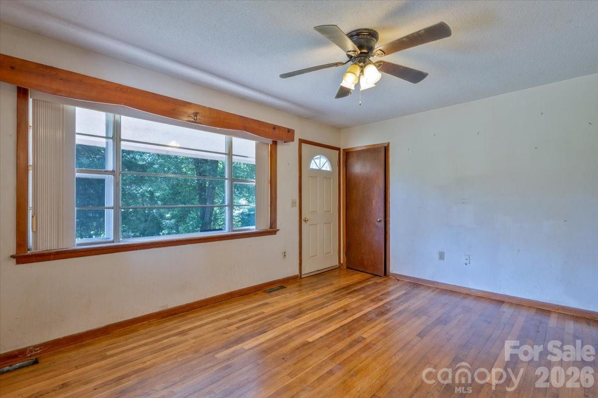 156 Old Sweetwater Road Robbinsville, NC 28771 - Photo 9 of 25 a view of an empty room with wooden floor and a window