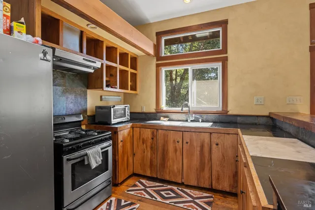 a kitchen with stainless steel appliances a stove and a cabinets