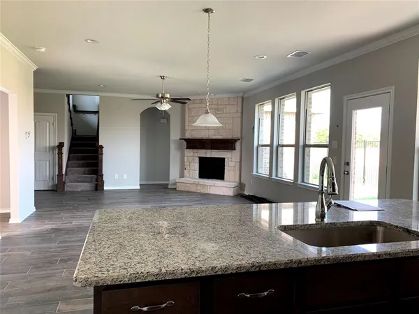 a kitchen with granite countertop a stove and a wooden floor