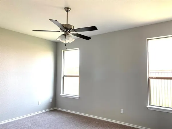 an empty room with a window and a fan