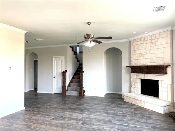 a view of a livingroom with wooden floor and a fireplace