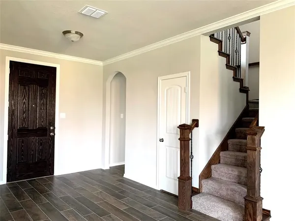 a view of a hallway with wooden floor and staircase