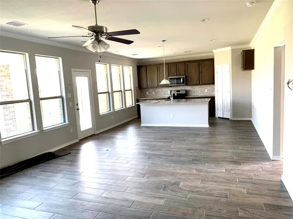 a view of kitchen with microwave a stove and wooden floor