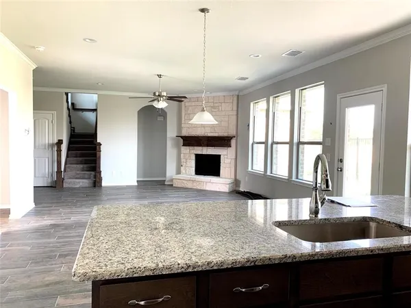 a kitchen with granite countertop a sink and a wooden floor