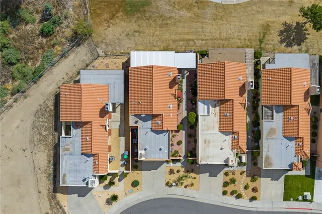 a front view of a house with a garden and a mountain
