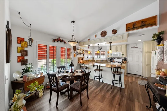a kitchen with stainless steel appliances wooden floor dining table and chairs