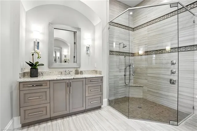 a bathroom with a shower sink and mirror