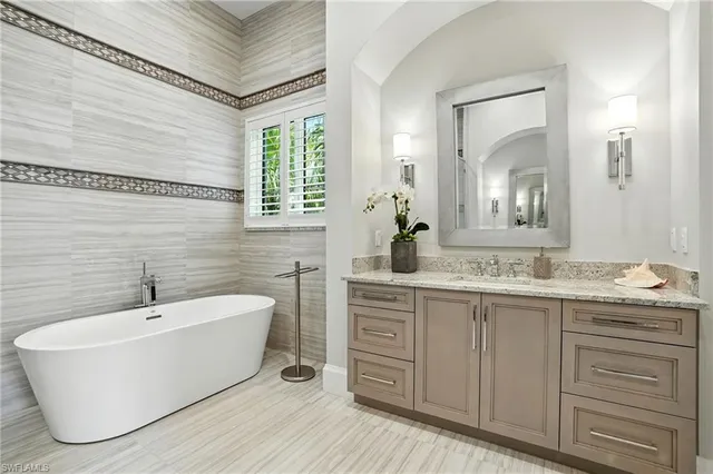 a bathroom with a double vanity sink a mirror and a bathtub