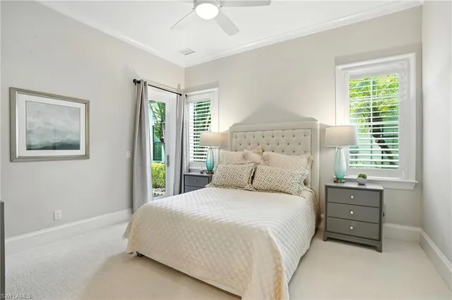 a bedroom with a bed a lamp and a large window