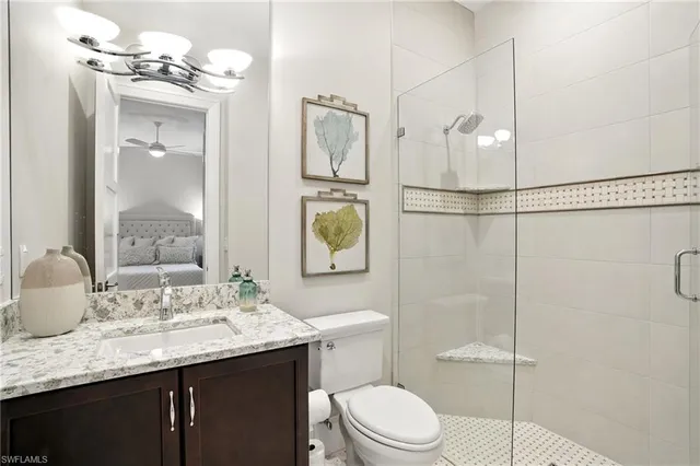 a bathroom with a granite countertop sink a toilet and shower