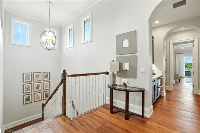 a view of a hallway with wooden floor and stairs