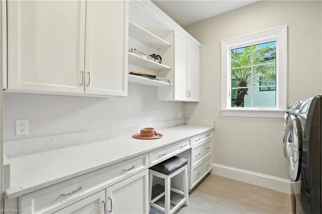 a kitchen with stainless steel appliances white cabinets and a window