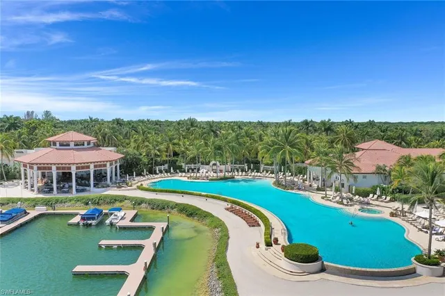 a view of a swimming pool with lawn chairs and plants