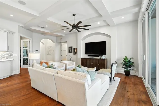 a living room with furniture a flat screen tv and a potted plant
