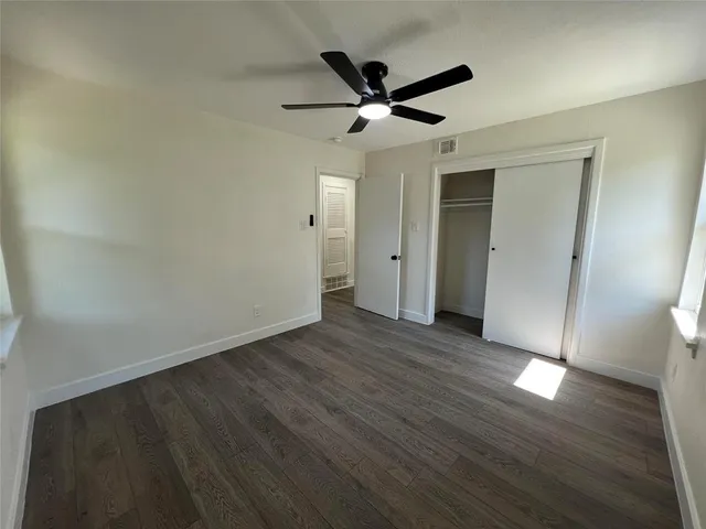 a view of a livingroom with wooden floor and a ceiling fan