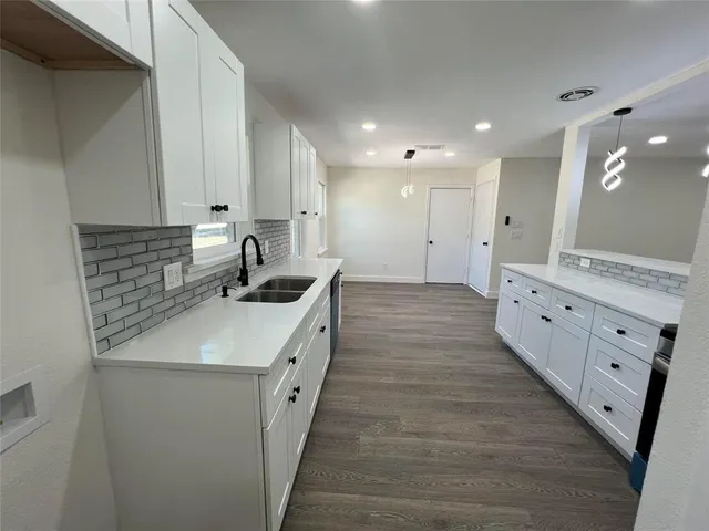 a large kitchen with stainless steel appliances granite countertop a stove and a sink