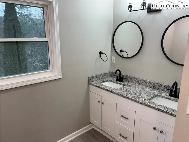 a bathroom with a granite countertop sink and a mirror