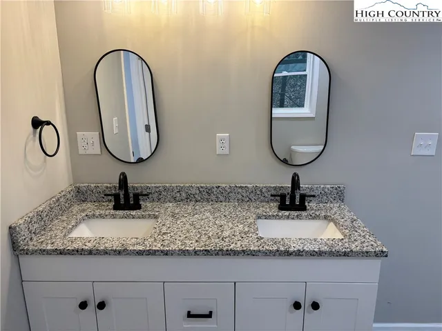 a bathroom with a granite countertop sink a mirror and vanity