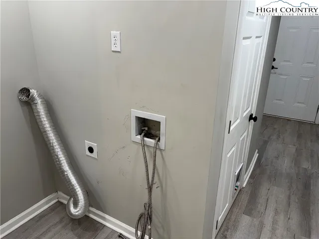 a view of a hallway with wooden floor and entryway