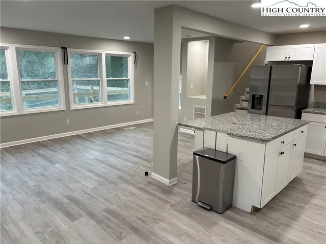 a kitchen with kitchen island a sink and wooden floor