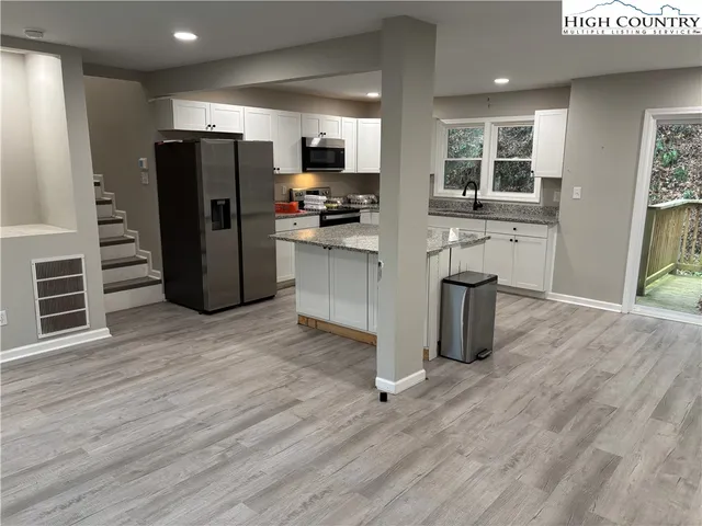 a kitchen with stainless steel appliances a refrigerator and wooden floor