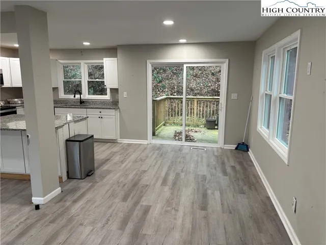 a view of a kitchen with wooden floor and a window
