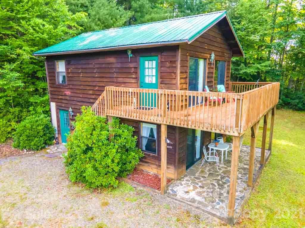 195 Mopey Maple Road Waynesville, NC 28785 - Photo 2 of 23 a view of a house with a yard deck and a garden