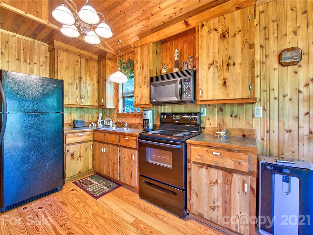 195 Mopey Maple Road Waynesville, NC 28785 - Photo 13 of 23 a kitchen with stainless steel appliances granite countertop a stove a sink and a microwave