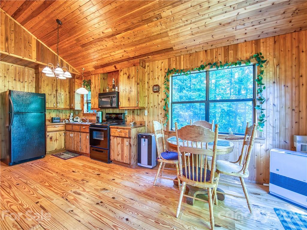 195 Mopey Maple Road Waynesville, NC 28785 - Photo 14 of 23 a kitchen with stainless steel appliances kitchen island granite countertop a table chairs and a refrigerator