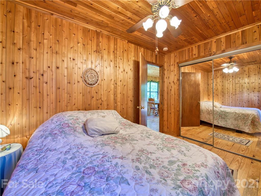 195 Mopey Maple Road Waynesville, NC 28785 - Photo 17 of 23 a bedroom with a bed and a chandelier