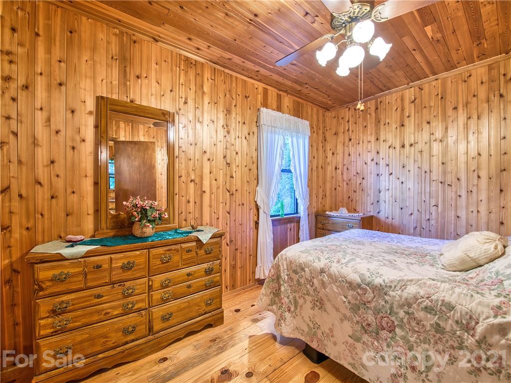 195 Mopey Maple Road Waynesville, NC 28785 - Photo 18 of 23 a bedroom with a bed and a mirror on a dresser