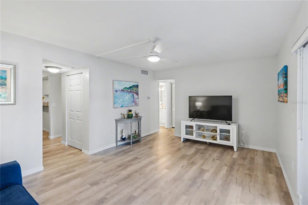 6157 Midnight Pass Road, Unit E23 Sarasota, FL 34242 - Photo 11 of 49 a view of a livingroom with wooden floor and a flat screen tv