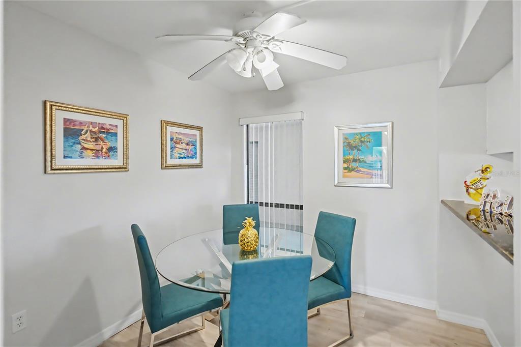 6157 Midnight Pass Road, Unit E23 Sarasota, FL 34242 - Photo 13 of 49 a view of a dining room with furniture and a chandelier