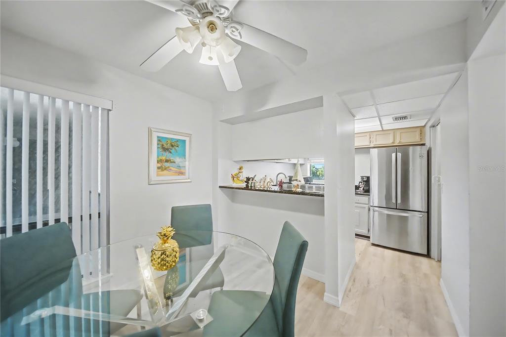 6157 Midnight Pass Road, Unit E23 Sarasota, FL 34242 - Photo 14 of 49 a kitchen with stainless steel appliances granite countertop a dining table chairs and chandelier