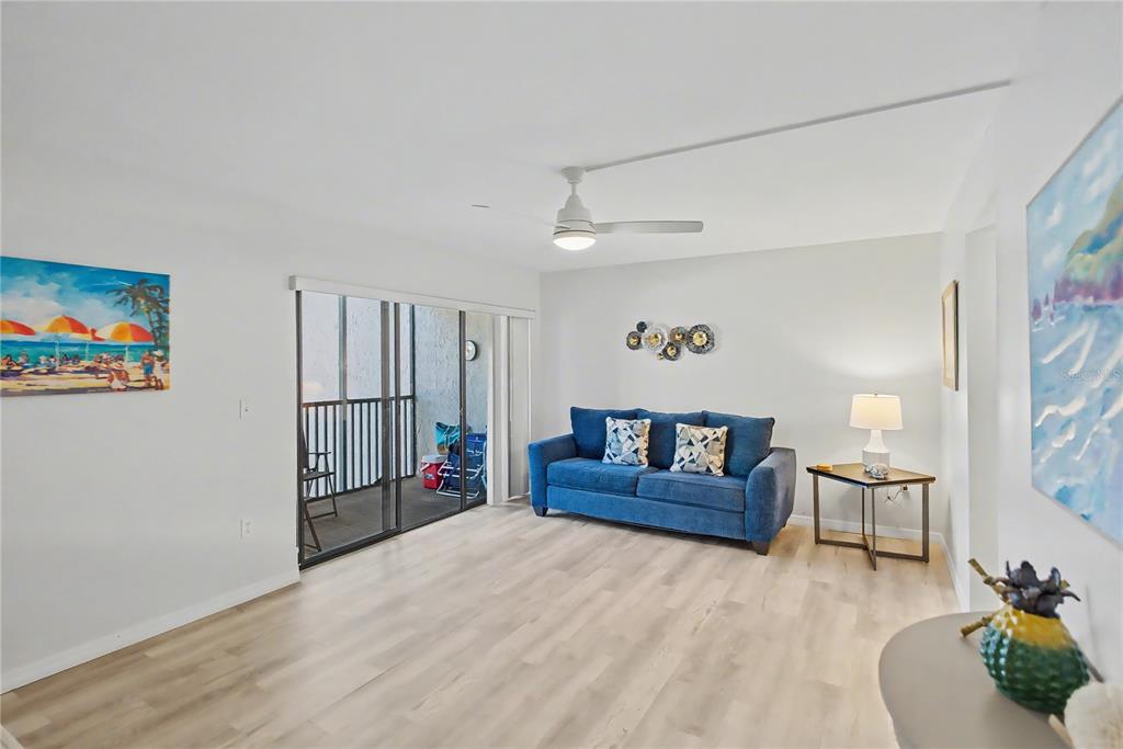 6157 Midnight Pass Road, Unit E23 Sarasota, FL 34242 - Photo 2 of 49 a living room with furniture and a wooden floor