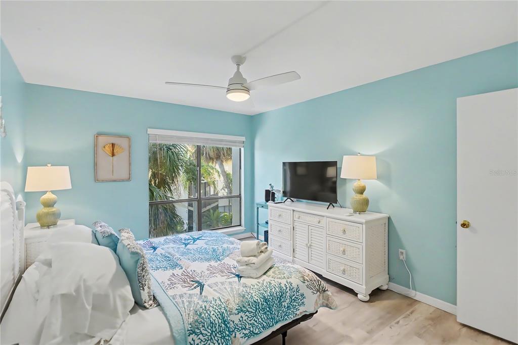6157 Midnight Pass Road, Unit E23 Sarasota, FL 34242 - Photo 21 of 49 a bedroom with a bed and a flat screen tv
