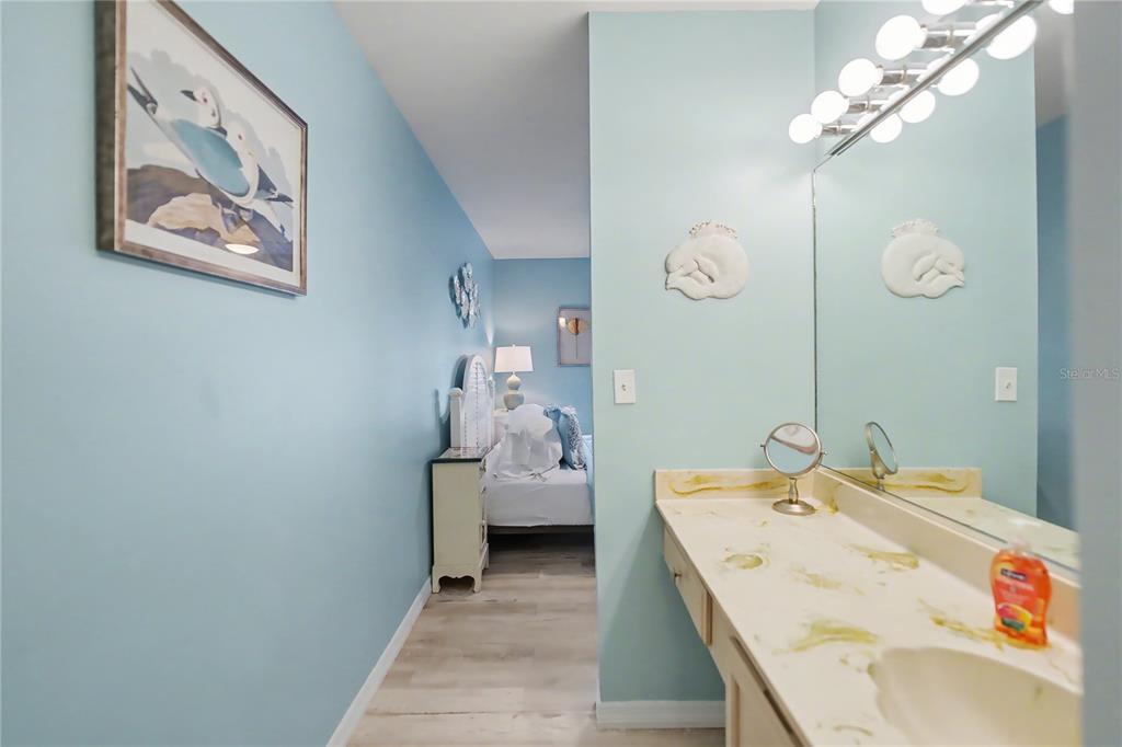 6157 Midnight Pass Road, Unit E23 Sarasota, FL 34242 - Photo 23 of 49 a bedroom with a bed and a chandelier