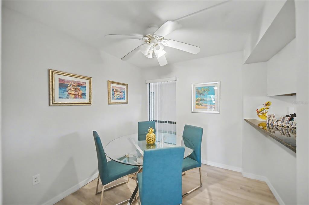 6157 Midnight Pass Road, Unit E23 Sarasota, FL 34242 - Photo 3 of 49 a view of a dining room with furniture and wooden floor