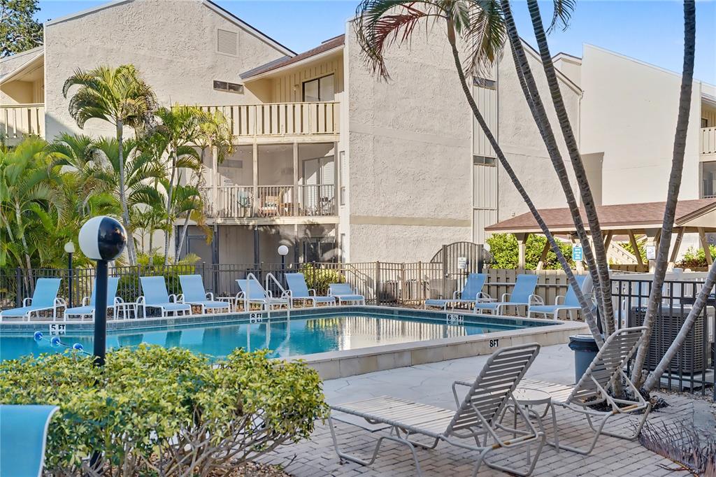 6157 Midnight Pass Road, Unit E23 Sarasota, FL 34242 - Photo 34 of 49 a view of balcony with two chairs and potted plants