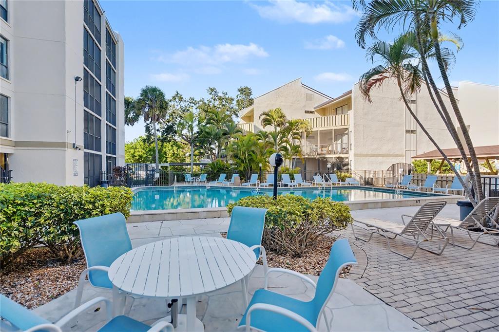 6157 Midnight Pass Road, Unit E23 Sarasota, FL 34242 - Photo 35 of 49 a view of a patio with couches table and chairs and potted plants