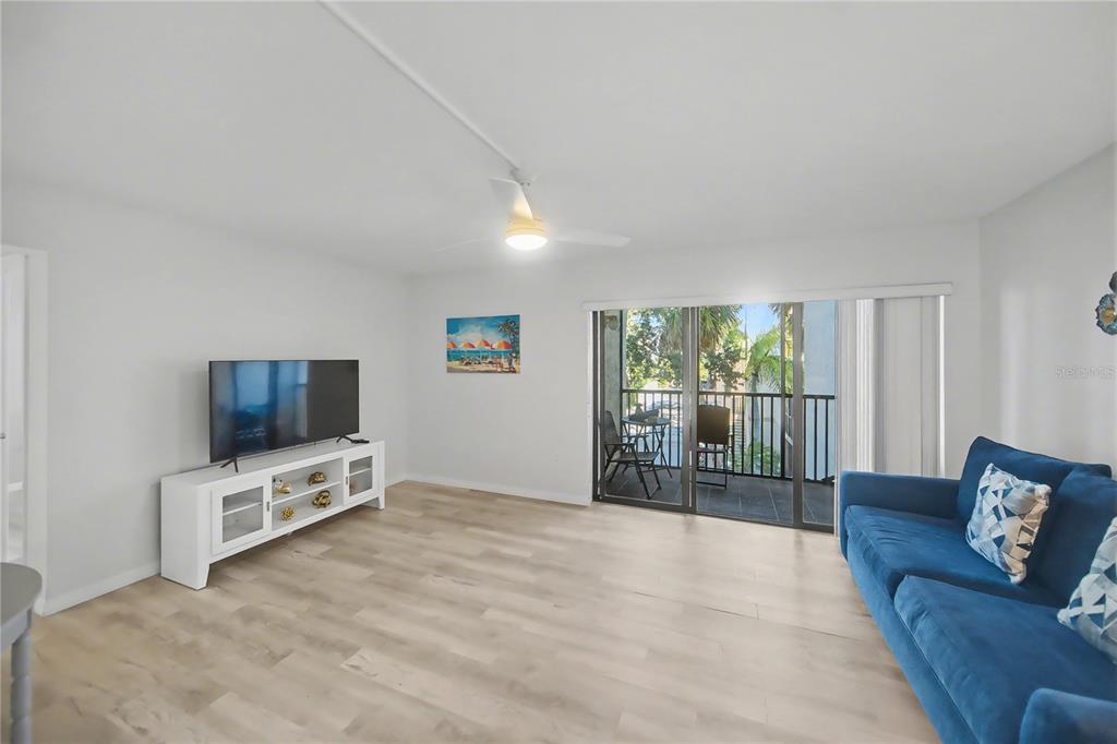 6157 Midnight Pass Road, Unit E23 Sarasota, FL 34242 - Photo 8 of 49 a living room with furniture and a flat screen tv