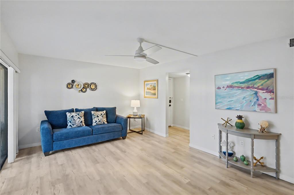 6157 Midnight Pass Road, Unit E23 Sarasota, FL 34242 - Photo 9 of 49 a living room with couch and a dining table with wooden floor